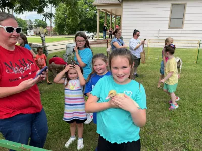 Child holding duck outside petting zoo