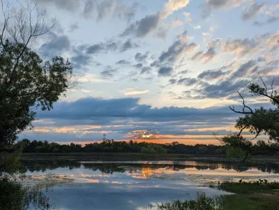 lake beach at sunrise with trees in the foreground