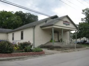 beige building surrounded by trees and bushes